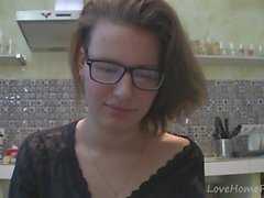 Solo tjej med glasögon chattar i köket
