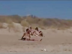 Coppie unica raggruppati per estranei su una spiaggia