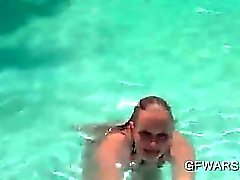 Hottie de adolescentes loura que trabalha seus peitos grandes de piscina